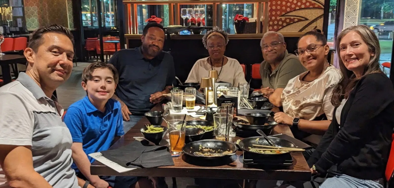 Patrice at dinner with family and childhood friends around a restaurant table